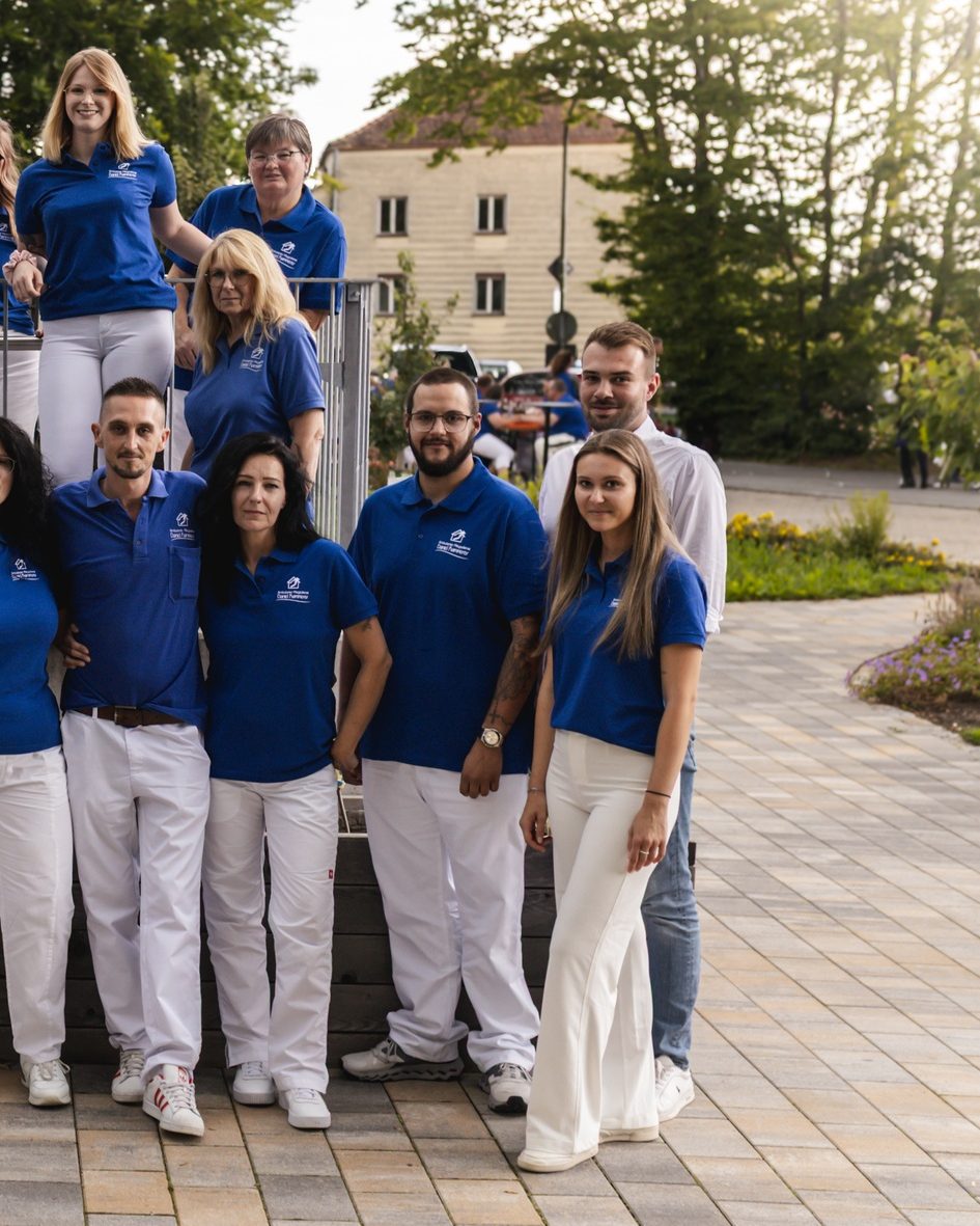 Mitarbeiterinnen und Mitarbeiter des Pflegedienstes Kammerer in blauen Poloshirts